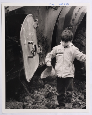 A Child Playing Next to a Military Vehicle 