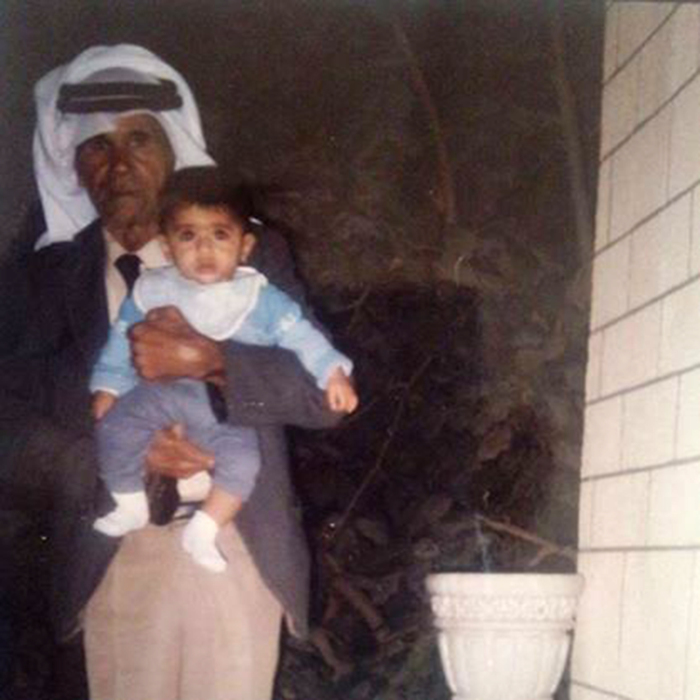 A Photograph of Abu Awny abu Aker Holding A Child in Dheisheh Palestinian Refugee Camp