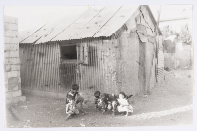 Children Playing in front of a House Built from Tin 