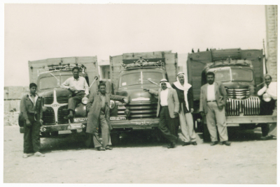 A Photograph of Men in front of Trucks