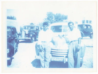 A Photograph of Two Men near a Taxi Car