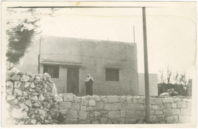 A women in front of her new house; which was levelled to the ground by the Israeli Occupation