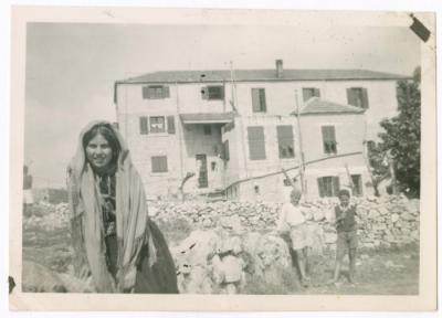 ريما ناصر بالثوب الفلسطيني خلف مبنى كلية بيرزيت، 1946
