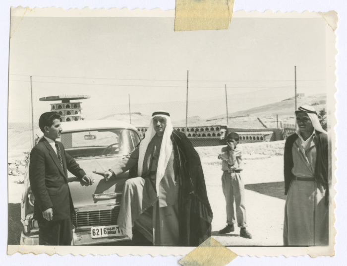 Men and a child next to a car