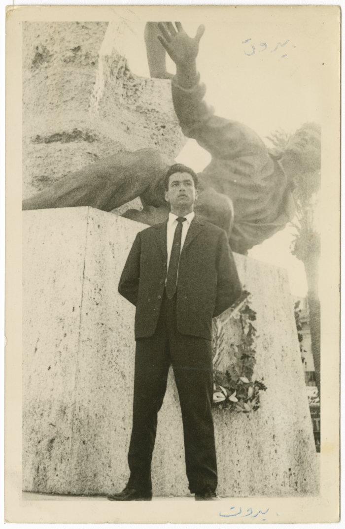 رجل أمام تمثال حجري يرمز للحرية، في ساحة البرج، خلال دراسته في الجامعة اللبنانية، في بيروت