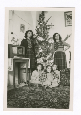Sisters Standing next to a Christmas Tree 