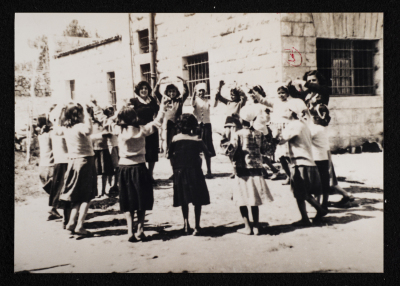 A Photograph of Teacher Elizabeth Naṣer with a Group of Pupils at Rawdat el-Zuhur School in al-Quds, 1960