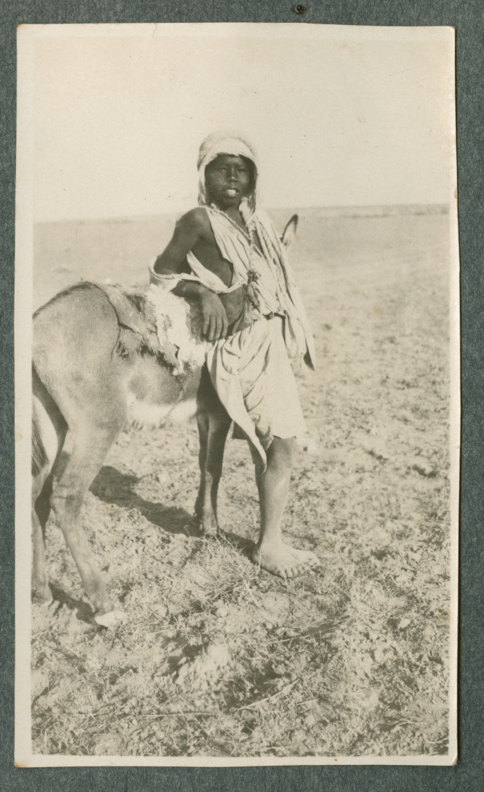 صورة لفتى يتَّكئ على حمار، [1920-50؟]