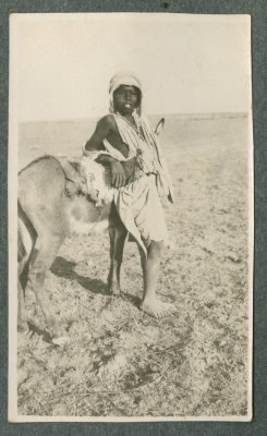 صورة لفتى يتَّكئ على حمار، [1920-50؟]