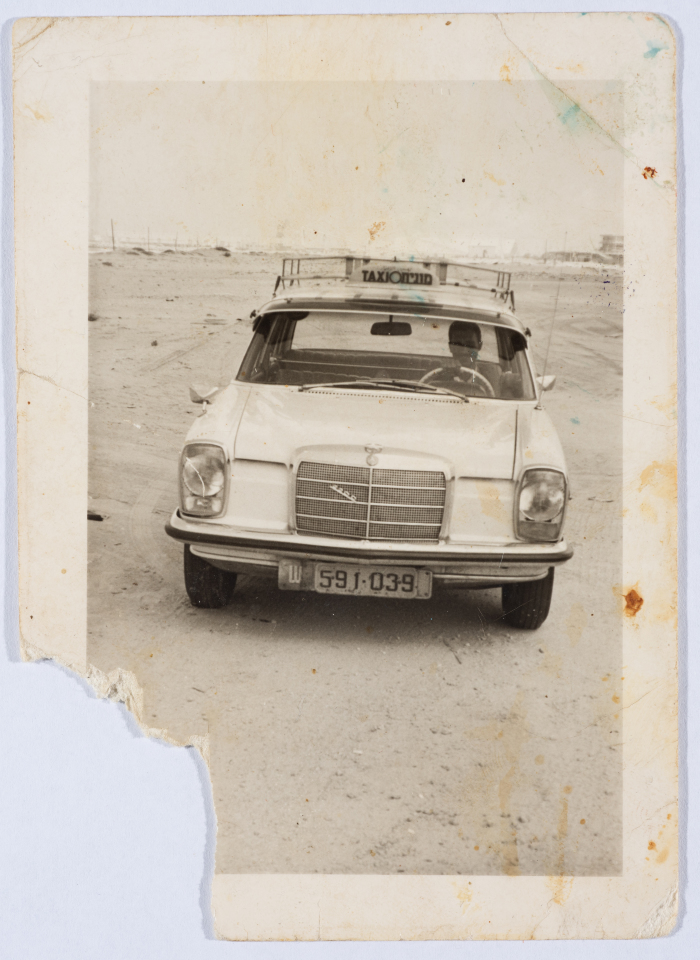 A Man Driving a Taxi for Etimad Taxi Service 