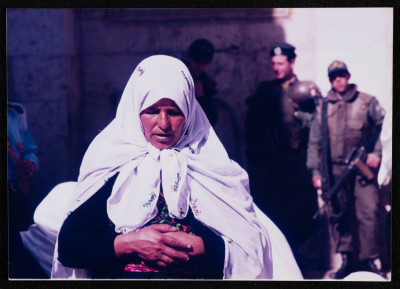 A Photograph of a Woman Praying in front of Israeli Soldiers