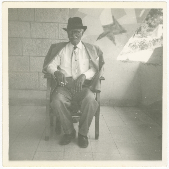A portrait of a Palestinian in front of his house