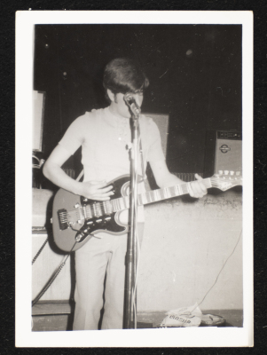 A Photograph of George Qurmuz Playing the Guitar at a show of Al-Bara