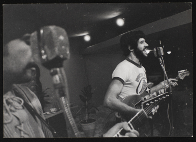 A Photograph of Samir Ashrawy Plays His Guitar at One of Al-Bara