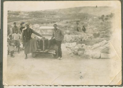 A Photograph of Men Standing by a Car 