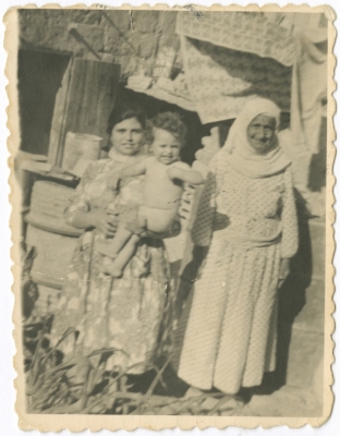 صورة لسيدة و ابنتها و حفيدها أمام بركية في شعب