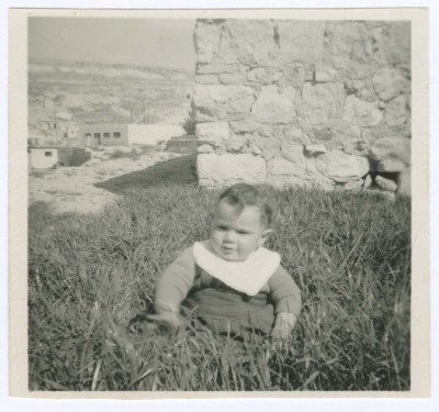 A Photograph of a Child Seated on the Grass
