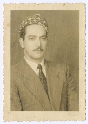 رجل يرتدي قبعة وبدلة وربطة عنق