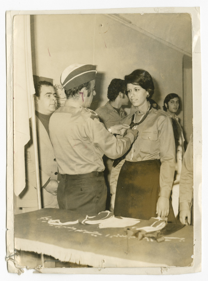 A Photograph of a Scout Member Fastening the Neckerchief of Another Female Scout