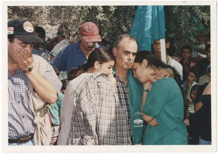 Hassan Abdelkader Asala embraces his daughters during the funeral of his killed son Asil Asala.