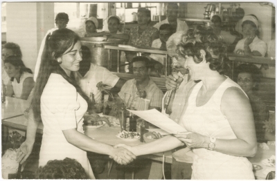 A photograph of a girl from the Naamneh family receiving her school certificate from Dar al-Muallimeen