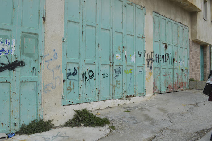 صورة لكتابات على أحد المحلات التجارية في مخيم الدهيشة، بيت لحم، 2015