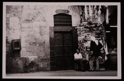 صورة لرجلان أمام أحد المحال التجارية في البلدة القديمة في مدينة القدس، تصوير يوسف البينا، عشرينيات وثلاثينيات القرن الماضي