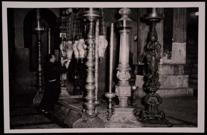 رجل دين داخل كنيسة القيامة في مدينة القدس، تصوير يوسف البينا، عشرينيات وثلاثينيات القرن العشرين