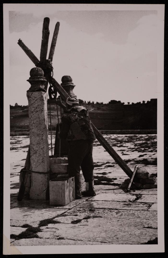 رجل يملأ الماء من أحد آبار الحرم القدسي الشريف، تصوير يوسف البينا، خمسينيات القرن العشرين