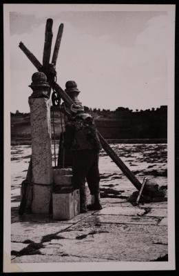 رجل يملأ الماء من أحد آبار الحرم القدسي الشريف، تصوير يوسف البينا، خمسينيات القرن العشرين