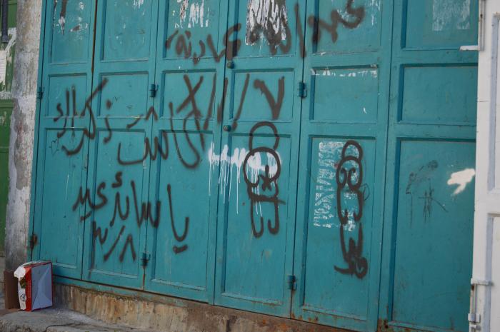 صورة لعبارات وشعارات وطنية على بوابة دُكّان في مخيم الدهيشة، بيت لحم، 2015