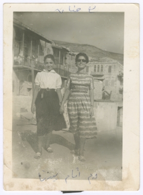 Enaya al-Fassed Standing in Front of Her House