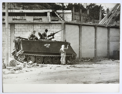 A Female Refugee Standing Next to a Tank