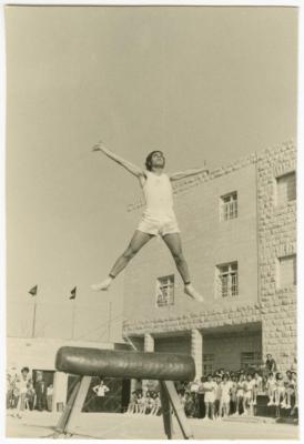 طالب يؤدي عرض جمباز على الحصان الخشبي، كلية بيرزيت، 1966