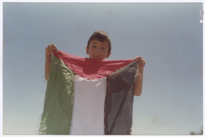 A Child Raisin the Palestinian Flag at Shaheed Omar al-Qasim