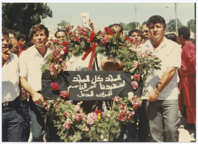 Men Holding a Wreath at Shaheed Omar al-Qasim