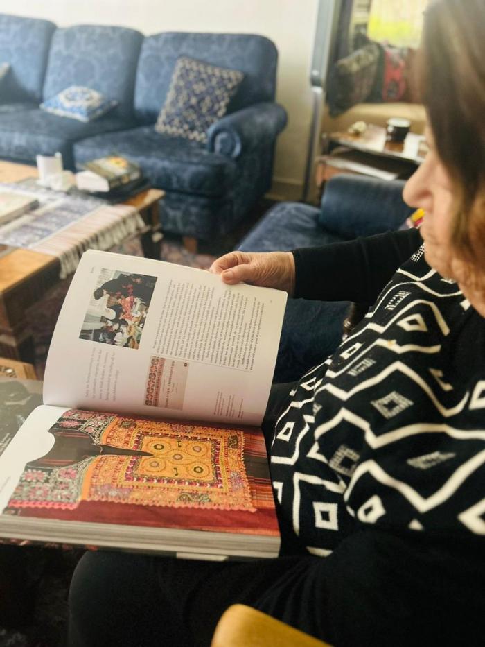 Widad Kawar is checking Threads of Identity Book, Amman, 2024
