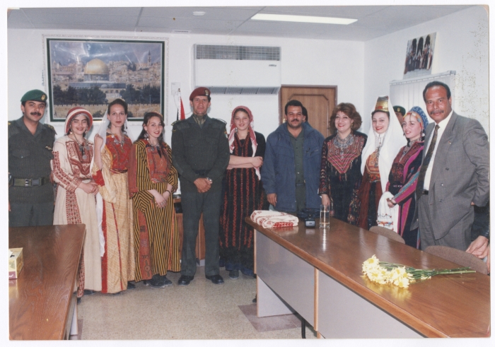 A group photo for a bunch of ladies wearing Palestinian traditional dresses