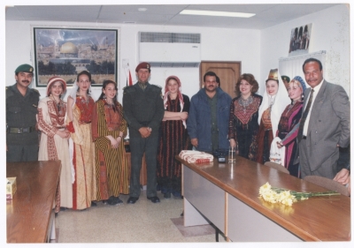 A group photo for a bunch of ladies wearing Palestinian traditional dresses