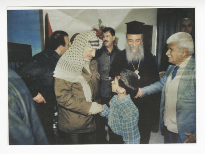 A Child Handshakes with Yassir Arafat on Christmas, 1990-1999