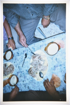 A Photograph of a Group of Men Having Mansaf at a Wedding Ceremony in Sa