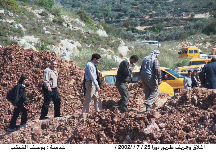 People passing to and from the village of Dura al-Qar'a after bulldozing and closing the road
