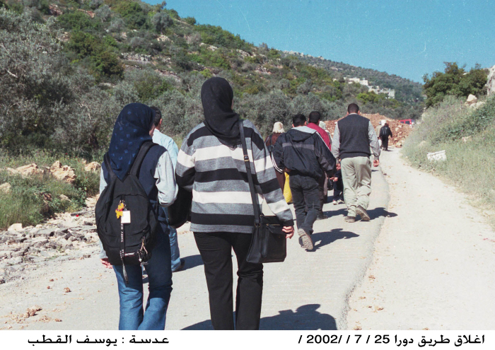 People passing to and from the village of Dura al-Qar'a after bulldozing and closing the road