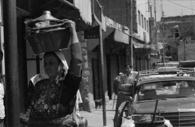 امرأة فلسطينية قرب سيارة أجرة في سوق البلدة القديمة، الخليل، 1987