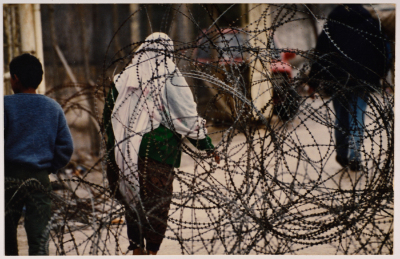 A Woman and a Child Standing by Barbed Wires 