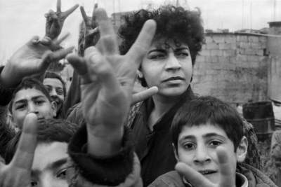 Woman surrounded by children. making victory sign El Askar refugee camp 1988