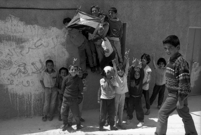 اطفال يلوّحون بالعلم الفلسطيني