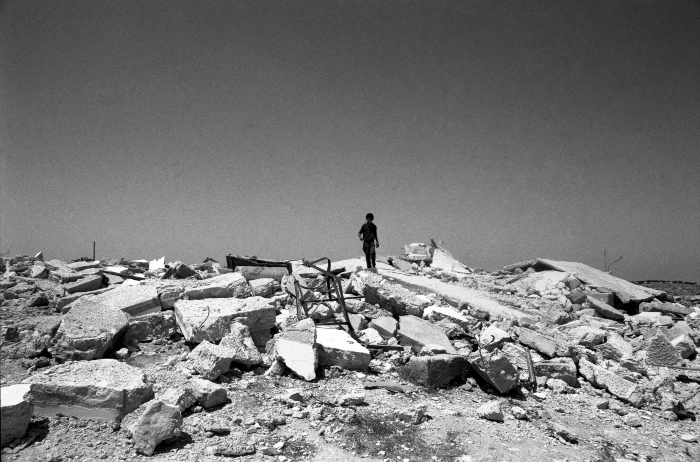 A Child Standing on the House's Ruins
