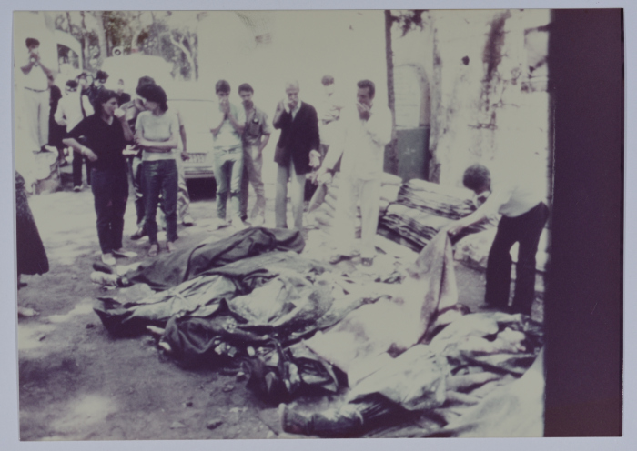 People Examining Covered Corpses 