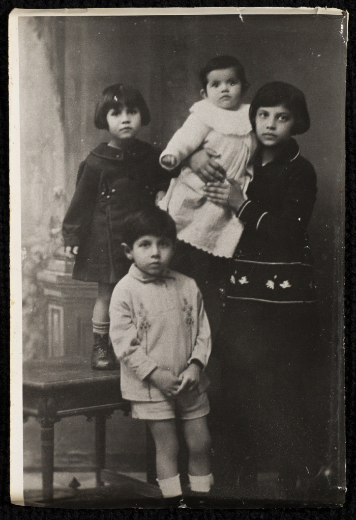 Serien al-Husseini holding her sister Hala; with her sister Malak al-Husseini to her right and their brother Hasan in the front